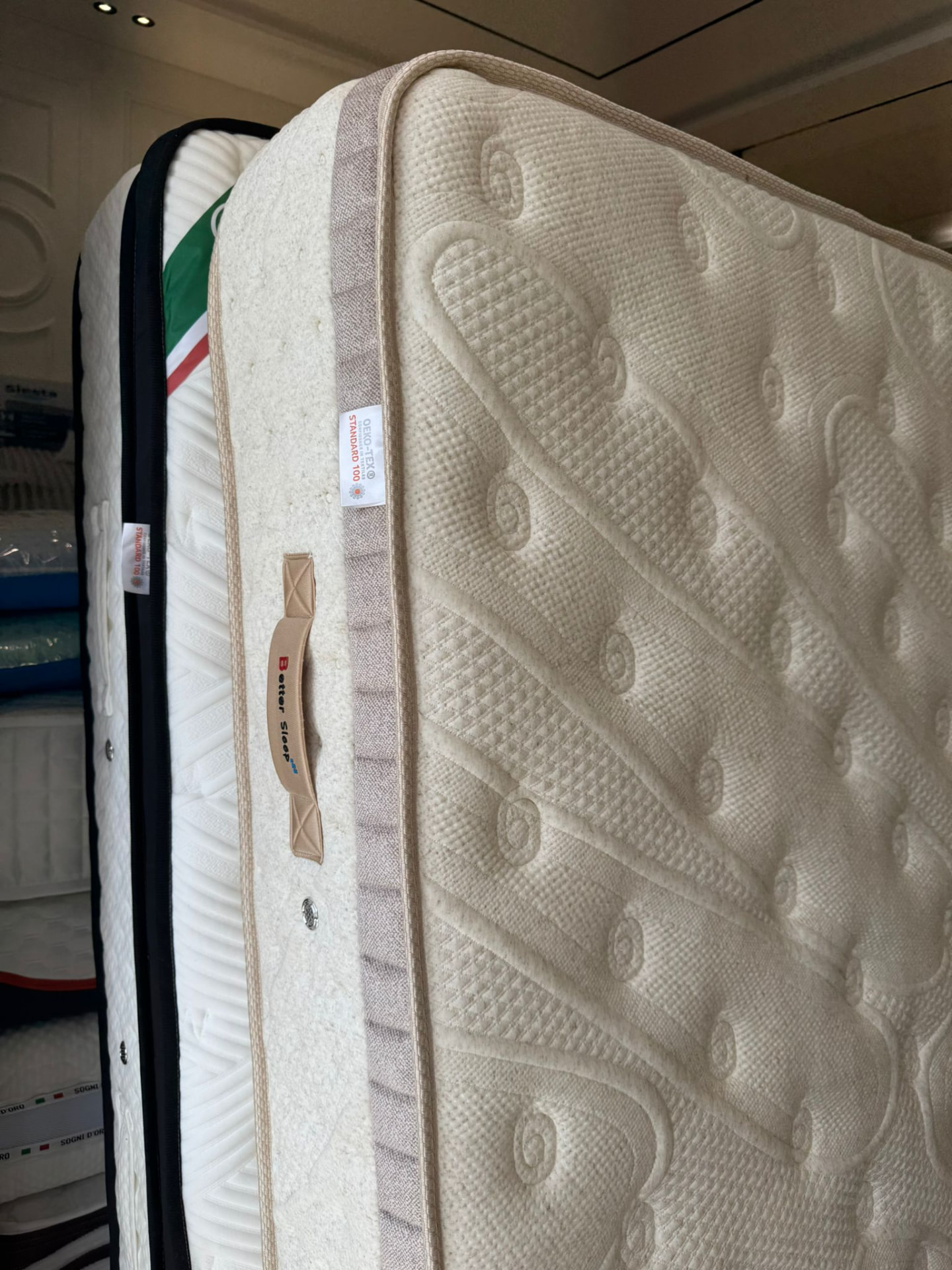 Détail du coutil ivoire d'un matelas, poignée latérale et finitions